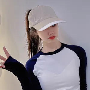 Close-up detail of khaki and white ponytail baseball cap, showing fabric and embroidery.