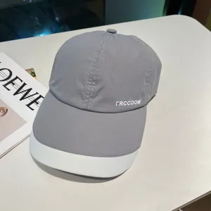 Detail shot of grey baseball cap featuring a white contrasting brim and side logo typography.