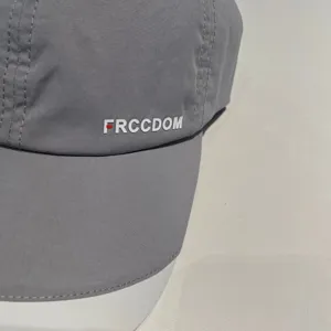 Grey quick-drying baseball cap detail, lightweight breathable fabric with clean white text.