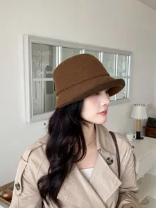 Detailaufnahme einer stilvollen braunen Damen-Bucket-Hat für kuschelige Wintermode.