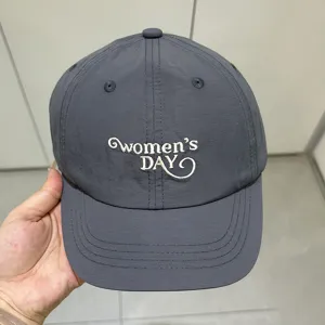 Detalle de la gorra de béisbol gris oscuro de secado rápido con elegante bordado blanco.
