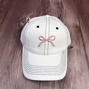 Casquette de baseball en denim lavé blanc avec nœud rose mignon et détails de broderie noire.