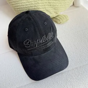 Nahaufnahme einer schwarzen, gewaschenen Baumwoll-Baseballkappe mit Stickerei.
