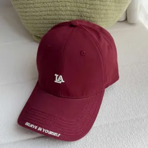 Burgundy baseball cap for women with LA logo embroidery, casual curved brim street style hat.