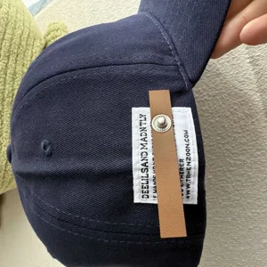 Detailed view of the vintage navy baseball cap featuring a stylish leather label and snap.