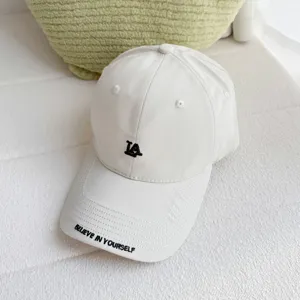 White baseball cap for women with LA embroidery and stylish brim quote, casual streetwear hat.