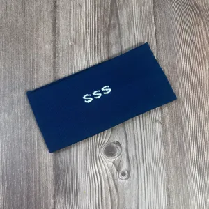Donkerblauwe gebreide hoofdband met witte geborduurde letters, warm en gezellig voor de winter.