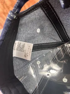 Vue détaillée de l'intérieur de la casquette en denim avec coutures et étiquette.