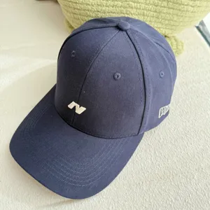Primer plano detalle de la gorra de beisbol azul marino con bordado N blanco y estilo.