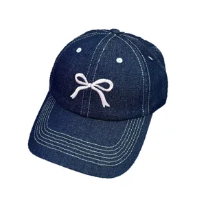 Casquette de baseball en jean bleu fonce classique avec jolie broderie de noeud rose.