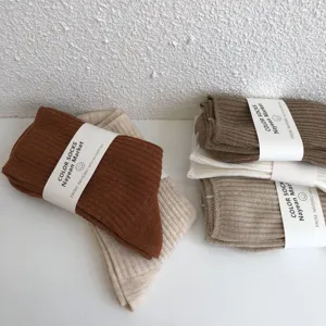 Detailed showcase of ribbed knit mid-tube cotton socks in warm autumn neutral tones.