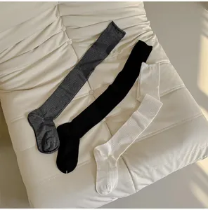 Ribbed long socks detail shot, showing high-density knit texture in grey, black, and white colors.