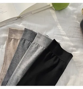 Primer plano detallado de cuatro leggings de color sólido en caqui, gris oscuro, claro y negro.