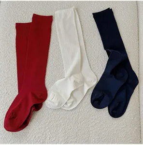 Detailed shot of ribbed knit long socks in red, white and navy blue colors, soft texture.