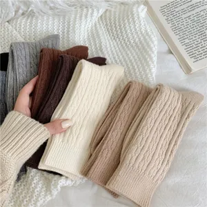 Close-up detail of women's thick thermal cable knit slouch socks in cozy neutral autumn colors.