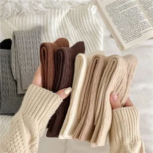 Detailed view of thick warm women cable knit slouch socks in autumn winter neutral colors.