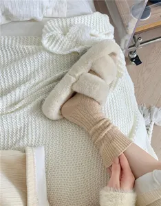 Cozy knit wool-blend sock detail with soft plush slipper in a warm autumn bedroom lifestyle.