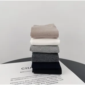 Detailed stacked view of men's solid color ribbed mid-tube socks in versatile neutral colors.