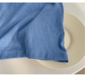 Close-up detail of blue ribbed knit fabric texture, showing soft material and fine stitching.