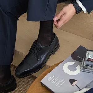 Vue rapprochée détaillée de chaussettes de ville noires confortables avec des chaussures.