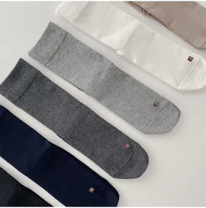 Close-up view of solid color men's mid-tube socks detail, showing fine knit texture and neat folding.