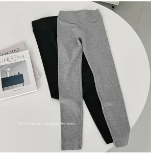 Pit-stripe seamless high-waist cropped yoga leggings detail view showing elastic fabric texture.