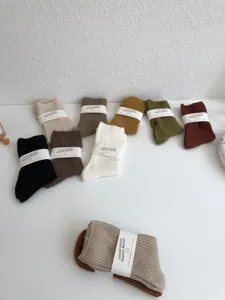 Detailed shot of solid color mid-calf cotton socks in various earthy Maillard tones.