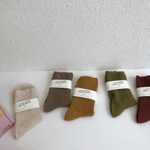 Solid color mid-tube cotton socks in Maillard brown and green tones, comfortable daily wear accessory.