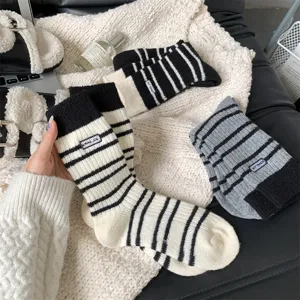 Detailed view of women's autumn winter thick warm striped faux wool knit socks with embroidery label.
