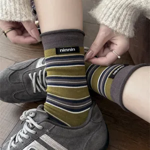 Detailed view of women's retro striped mid-tube socks with stylish brand label cuff