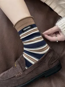 Detailed close up view of women autumn winter vintage style striped rolled cuff cotton socks.