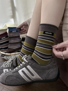 Detailed shot of vintage striped cotton mid-tube socks with woven label and rolled cuff.