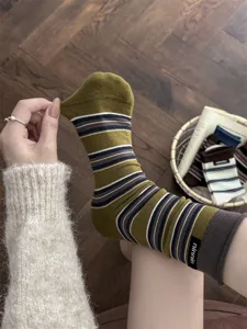Detail view of women's autumn winter retro striped cotton mid-tube slouch socks with cute label.