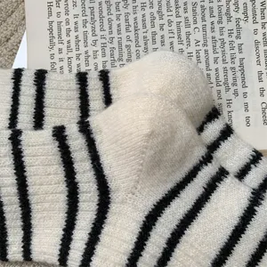 Detailed shot of women's thick warm striped wool-like mid-tube socks, soft and cozy texture.