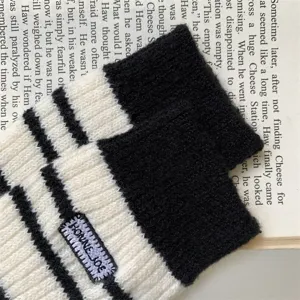 Close-up detail of cozy black and white striped knit winter women socks with embroidery label.