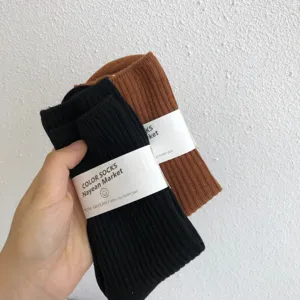 Autumn winter solid color women mid tube cotton socks with brown and black variant display.