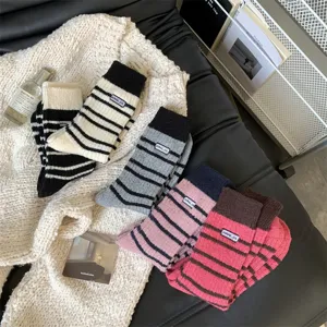 Cozy thick striped knit women's winter socks with embroidered badge detail, warm and soft.