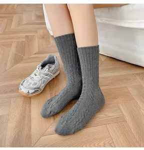 Primo piano di calzini medi spessi in maglia treccia grigio scuro, dettaglio caldo.