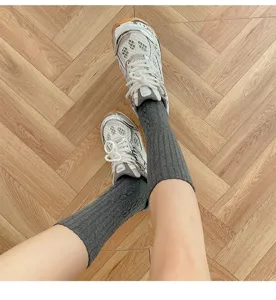 Dettaglio in primo piano di calzini medi a coste spesse da donna con scarpe da ginnastica.