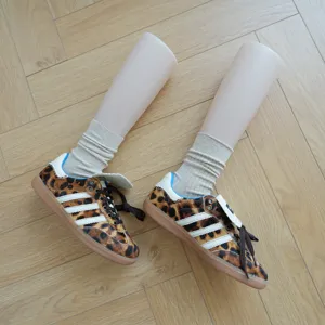 Detail view of stylish ribbed mid-calf crew socks in chic neutral tone paired with shoes.