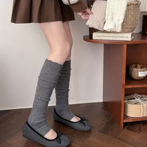 Detailed view of grey knit stirrup leg warmers for women, cozy winter slouch socks style.