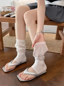 Gros plan montrant la texture transparente et le design sans pied des chaussettes de jambe blanches.