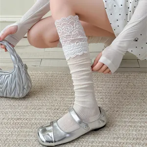 Close-up of sweet Lolita lace trim long stack socks paired with stylish silver Mary Jane shoes.