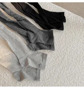 Detailed shot of soft ribbed leggings in various colors on cozy plush blanket background.