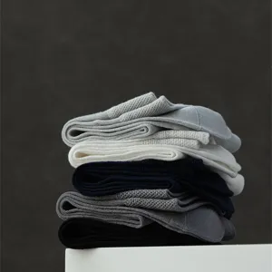 Vue détaillée de chaussettes pour hommes fines et respirantes empilées en plusieurs teintes.