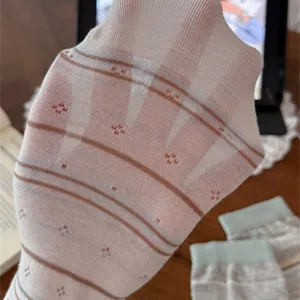 Primo piano dettagliato di calzini estivi sottili da donna con righe retrò e tessuto trasparente.