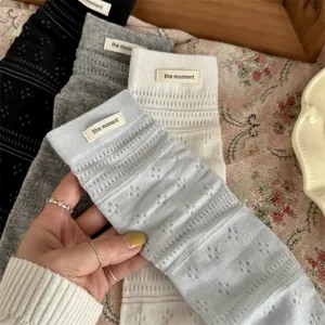 Detailed shot of Japanese hollow knit stacked socks with fabric labels in multiple colors soft.