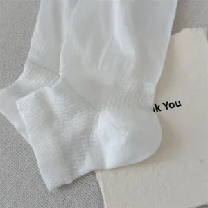 Close-up detail of white thin rolled edge ballet socks, soft breathable summer leg warmers.