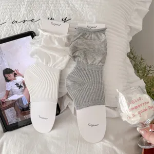 Vue détaillée de jambières style ballet avec étriers, chaussettes douces en blanc et gris.