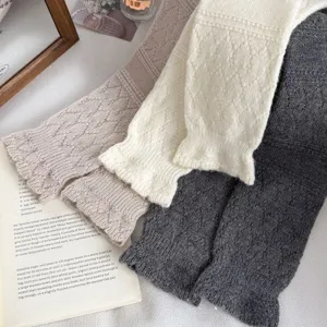 Knitted wool leg warmers detail shot, showing exquisite diamond pattern and soft texture.